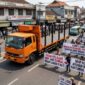 Ilustrasi foto AI armada angkutan kayu PT MHP masih melintas di jalanan pusat Kota Pendopo pasca kejadian tabrak lari. ((Dok/tintamerah).
