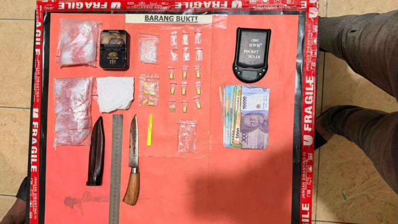 Inilah deretan barang bukti hasil penggerebekan di Tanjung Raja, Ogan Ilir, mulai dari paket sabu, timbangan digital, senjata tajam, hingga uang tunai. Penangkapan ini mengungkap modus pelaku yang menggunakan buku catatan khusus untuk memantau transaksi narkotika di wilayah tersebut. (Foto: Dok/Polda Sumsel)