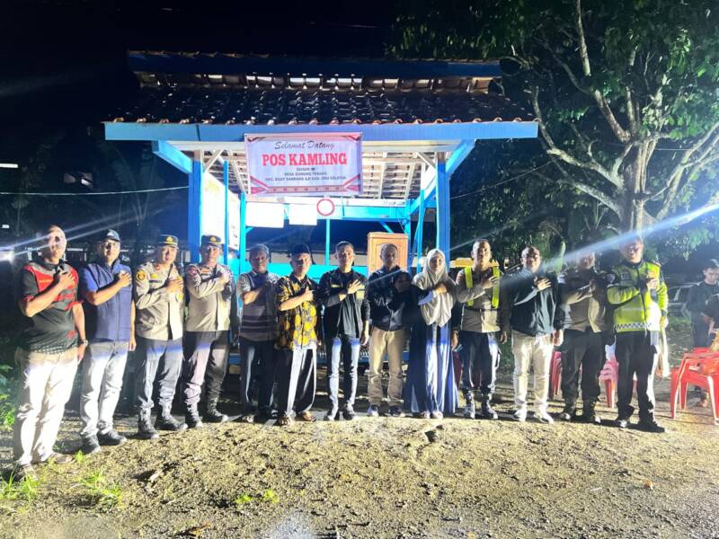 Kapolres OKU Selatan, AKBP I Made Redi Hartana, S.H., S.I.K., M.I.K., berfoto bersama warga dan jajaran di depan Pos Kamling Desa Gunung Terang saat peluncuran intensif program SAROMA (Sambang Ronda Malam), Kamis (16/4). Selain mempererat silaturahmi, kegiatan ini fokus pada penguatan pengamanan swakarsa dan pemberian sarana kontak untuk meningkatkan kewaspadaan masyarakat di jam rawan.  (Foto: Dok/Polda Sumsel)