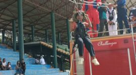 UJI NYALI DAN MENTAL TANGGUH: Salah seorang anak dengan penuh keceriaan mencoba wahana Flying Fox gratis yang digelar oleh Dinas Pemadam Kebakaran dan Penyelamatan (Damkar) PALI di Lapangan Tribun Gelora November Pertamina Pendopo, Talang Ubi, Minggu (7/6/2026). Wahana edukasi adrenalin ini dipadati ratusan warga pada momen Sunday Morning dengan pengawasan ketat personel Damkar demi menjamin 
