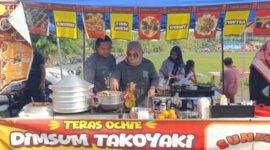 Pelaku UMKM kuliner ‘Disum Takoyaki’, Putri Febi Anggraini saat melayani pembeli pada gelaran Sunday Morning di Lapangan Sanggar Pramuka Gelora November Pertamina Pendopo, Talang Ubi, PALI, Minggu (7/6/2026). Meski mampu meraup omzet hingga Rp1,5 juta per hari, para pedagang mendesak Pemerintah Kabupaten PALI untuk segera memfasilitasi kebutuhan mendasar seperti penerangan dan instalasi listrik publik agar roda ekonomi kerakyatan tidak terhambat keterbatasan (Foto: Dok/tintamerah.co)