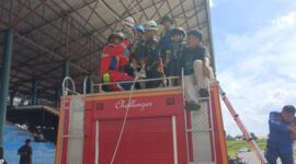 Petugas Damkar PALI dengan sigap memasang tali pengaman (harness) pada anak-anak warga di atas mobil rescue 