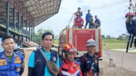 Kepala Bidang Penanggulangan Kebakaran dan Penyelamatan Dinas Damkar PALI, Suyadi (kedua dari kiri, rompi biru), saat diwawancarai oleh wartawan tintamerah.co di sela-sela memantau jalannya wahana flying fox gratis di Lapangan Tribun Gelora November Pertamina Pendopo, Talang Ubi, Minggu (7/6/2026). Suyadi menegaskan pelaksanaan kegiatan mengutamakan keselamatan penuh (zero accident) sesuai instruksi pimpinan, sekaligus mengevaluasi masukan warga untuk pengembangan kegiatan ke depan.  (Foto: Dok/tintamerah.co)