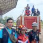 Kepala Bidang Penanggulangan Kebakaran dan Penyelamatan Dinas Damkar PALI, Suyadi (kedua dari kiri, rompi biru), saat diwawancarai oleh wartawan tintamerah.co di sela-sela memantau jalannya wahana flying fox gratis di Lapangan Tribun Gelora November Pertamina Pendopo, Talang Ubi, Minggu (7/6/2026). Suyadi menegaskan pelaksanaan kegiatan mengutamakan keselamatan penuh (zero accident) sesuai instruksi pimpinan, sekaligus mengevaluasi masukan warga untuk pengembangan kegiatan ke depan.  (Foto: Dok/tintamerah.co)