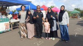Kepala Dinas Koperasi dan UKM PALI, Rohman (tengah, kaos hitam), berfoto bersama pelaku UMKM Bubur Ayam Bandung, Santi Yulianti (baju abu-abu berhijab hitam memakai kacamata), di sela kegiatan Sunday Morning Lapangan Sanggar Pramuka Gelora November Pertamina Pendopo, Talang Ubi, PALI, Minggu (7/6/2026). (Foto: Dok/tintamerah.co)
