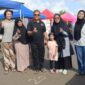 Kepala Dinas Koperasi dan UKM PALI, Rohman (tengah, kaos hitam), berfoto bersama pelaku UMKM Bubur Ayam Bandung, Santi Yulianti (baju abu-abu berhijab hitam memakai kacamata), di sela kegiatan Sunday Morning Lapangan Sanggar Pramuka Gelora November Pertamina Pendopo, Talang Ubi, PALI, Minggu (7/6/2026). (Foto: Dok/tintamerah.co)