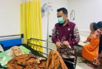 Dengan tatapan penuh empati, Lurah Talang Ubi Timur, Aan Supriadi, SE., MM, mengawal langsung penanganan medis warga lansia yang tengah terbaring sakit di Rumah Sakit Mahkota Kabupaten PALI, Kamis (11/6/2026). Aksi cepat tanggap ini merupakan wujud nyata instruksi Bupati PALI Asgianto, ST, agar seluruh aparatur pemerintah selalu hadir memberikan pelayanan yang humanis, tulus, dan meruntuhkan sekat birokrasi demi masyarakat yang membutuhkan. (Foto: Istimewa)
