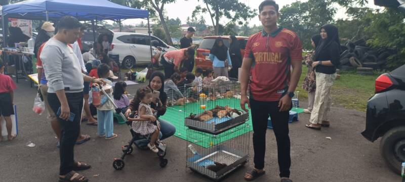 Alamsyah berpose di tenant miliknya, sebuah inovasi pemancingan kelinci yang menjadi daya tarik baru dalam perhelatan Sunday Morning di Lapangan Sanggar Pramuka, Gelora November Pertamina, Pendopo, pada Minggu, (21/6/2026). (Foto: Dok/tintamerah.co)