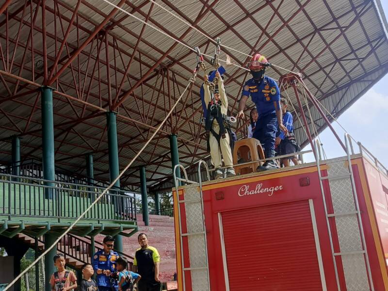 Seorang anak (Shaquille Oniel) didampingi personel Damkar PALI meluncur di wahana flying fox dalam Sunday Morning di Gelora November Pertamina Pendopo, Minggu (2/8/2026). Warga antusias mengapresiasi inisiatif ini sebagai sarana pembentukan mental dan keberanian anak sejak dini. (Foto: Dok/Istimewah)
