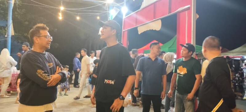 Bupati PALI Asgianto saat berdiskusi santai dengan Kepala Dinas Koperasi dan UKM PALI, Rohman, di lokasi PALI Night Culinary, Sanggar Pramuka Gelora November, Pendopo, Sabtu malam (8/8/2026). (Foto: Dok/tintamerah,co)