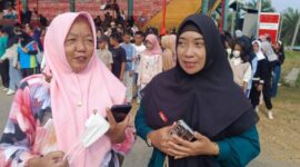 Guru pendamping dari SMP YKPP Pendopo, Rissa Eka Donawati (kanan), saat memberikan keterangan kepada tintamerah.co mengenai kesiapan 100 siswa-siswi gabungan SMPN 1 Talang Ubi dan SMP YKPP Pendopo dalam gladi bersih paduan suara HUT RI ke-81 di Stadion Gelora November, Sabtu (15/8/2026). (Foto: Dok/tintamerah.co)  
