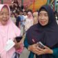 Guru pendamping dari SMP YKPP Pendopo, Rissa Eka Donawati (kanan), saat memberikan keterangan kepada tintamerah.co mengenai kesiapan 100 siswa-siswi gabungan SMPN 1 Talang Ubi dan SMP YKPP Pendopo dalam gladi bersih paduan suara HUT RI ke-81 di Stadion Gelora November, Sabtu (15/8/2026). (Foto: Dok/tintamerah.co)  