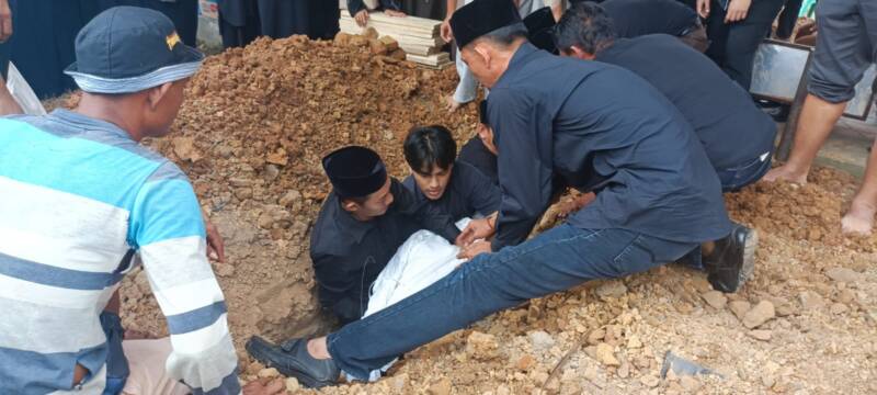Bupati PALI, Asgianto, ST, terlihat khusyuk dan menahan duka mendalam saat memimpin langsung prosesi pemakaman almarhumah ibunda tercinta di liang lahat, TPU Kebun Bunga, Palembang, Jumat (11/9/2026). (Foto: Dok/tintamerah.co)